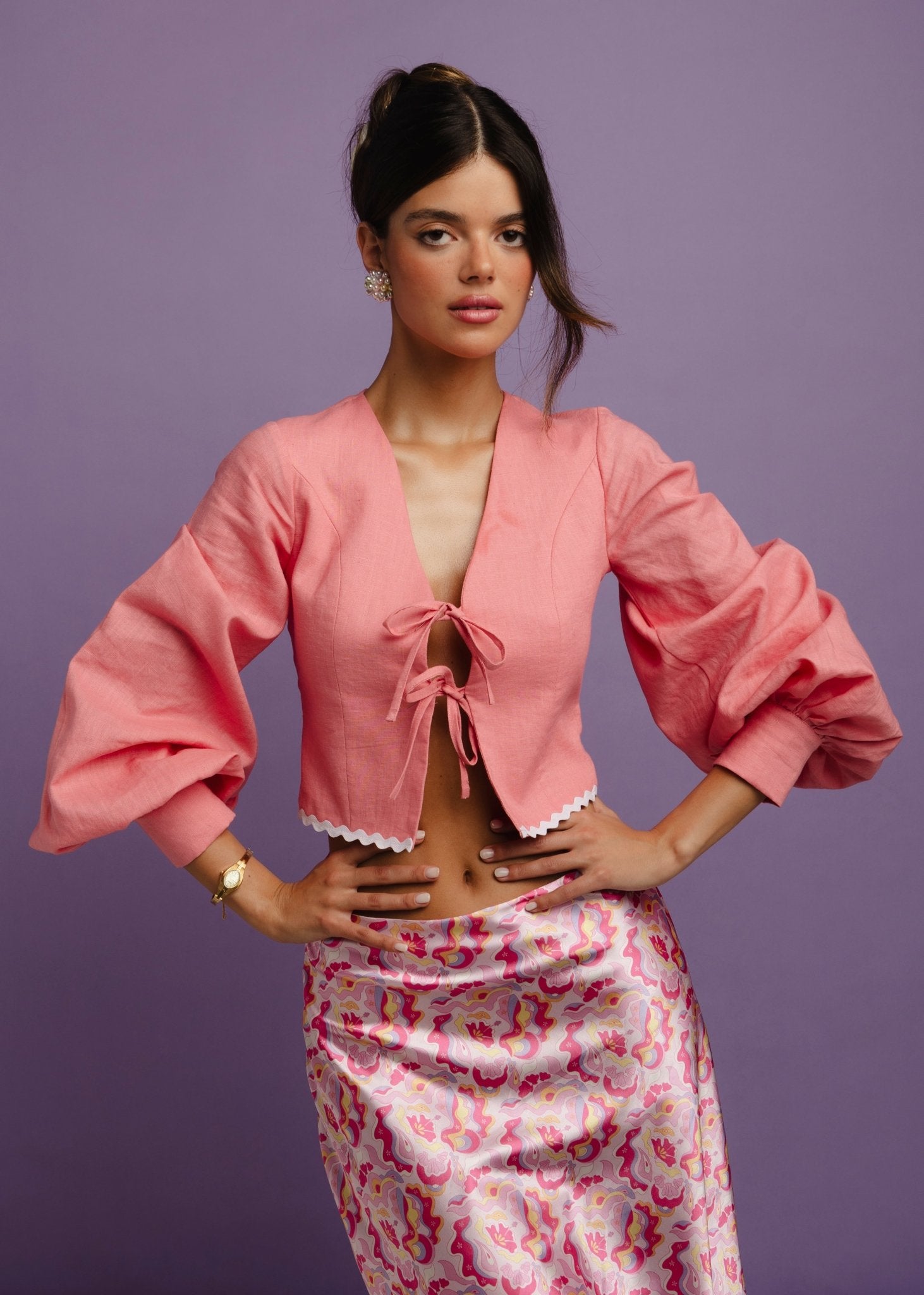 <img src="guavaglowskirtdetails" alt="Detailed view of a Model wearing a pink retro pattern satin skirt with a flattering bias cut. Perfect outfit for a brunch at the beach club.">