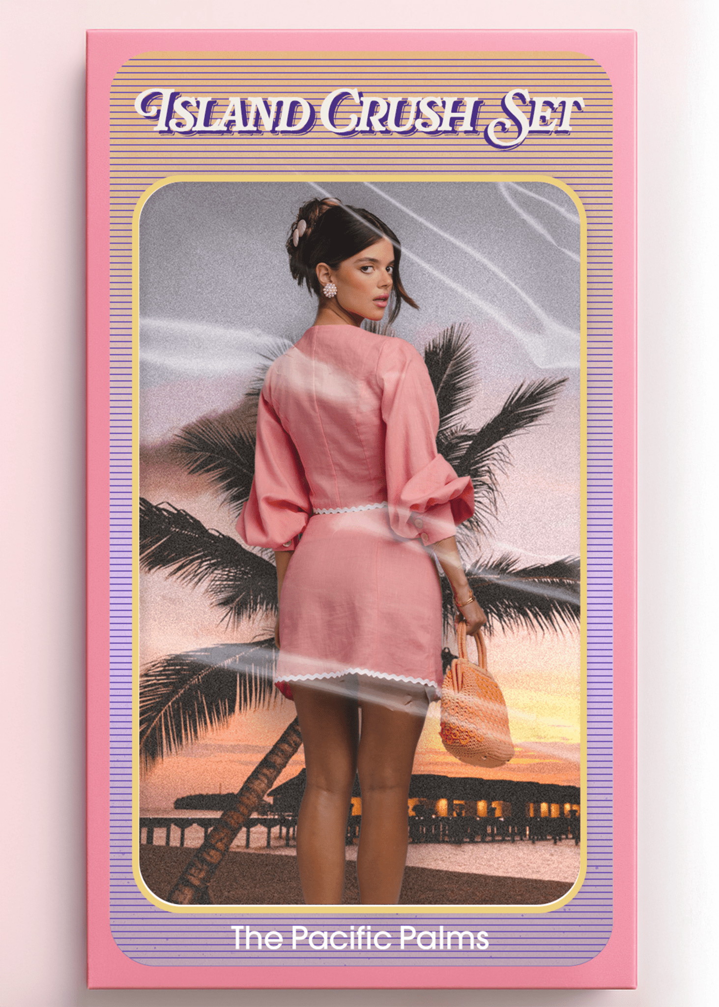<img src="islandcrushsetbackview" alt="Island Crush Set – The Pacific Palms. Model shown from the back inside a vintage doll-style packaging box, wearing a pink co-ord outfit with white trim and holding an orange woven bag. Styled like a retro toy against a sunset beach with palm trees and overwater bungalows.">