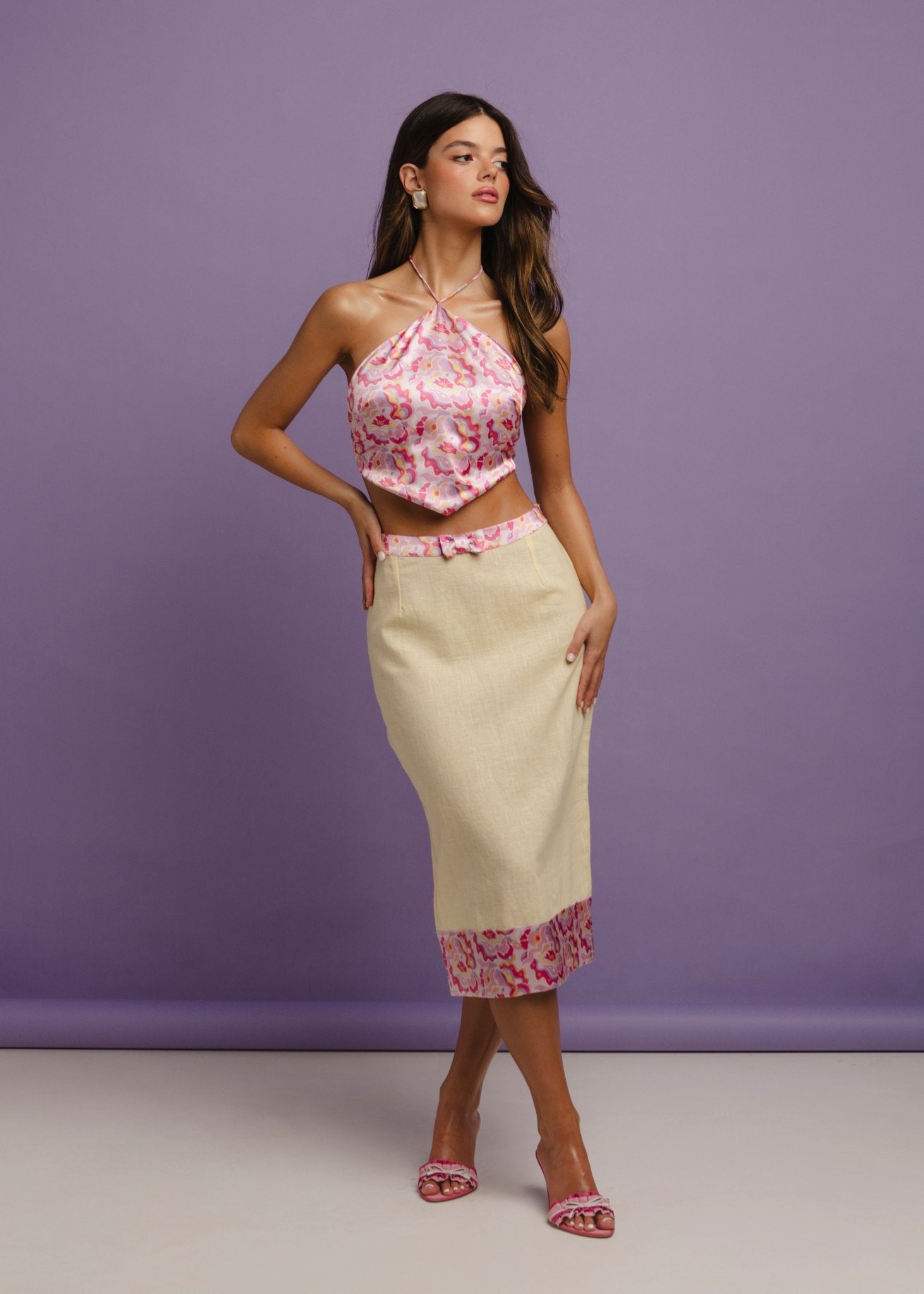 <img src="sunnnychicskirtfulllook3" alt="Full look of a Model wearing a flattering yellow linen pencil skirt with a retro pattern on the hem and a bow detail on the belt, styled with a pink retro pattern satin top with V shape style hem.The perfect office look for summer days.">